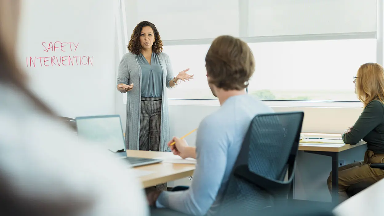 Female programme trainer in front of a flip chart for Safety Intervention