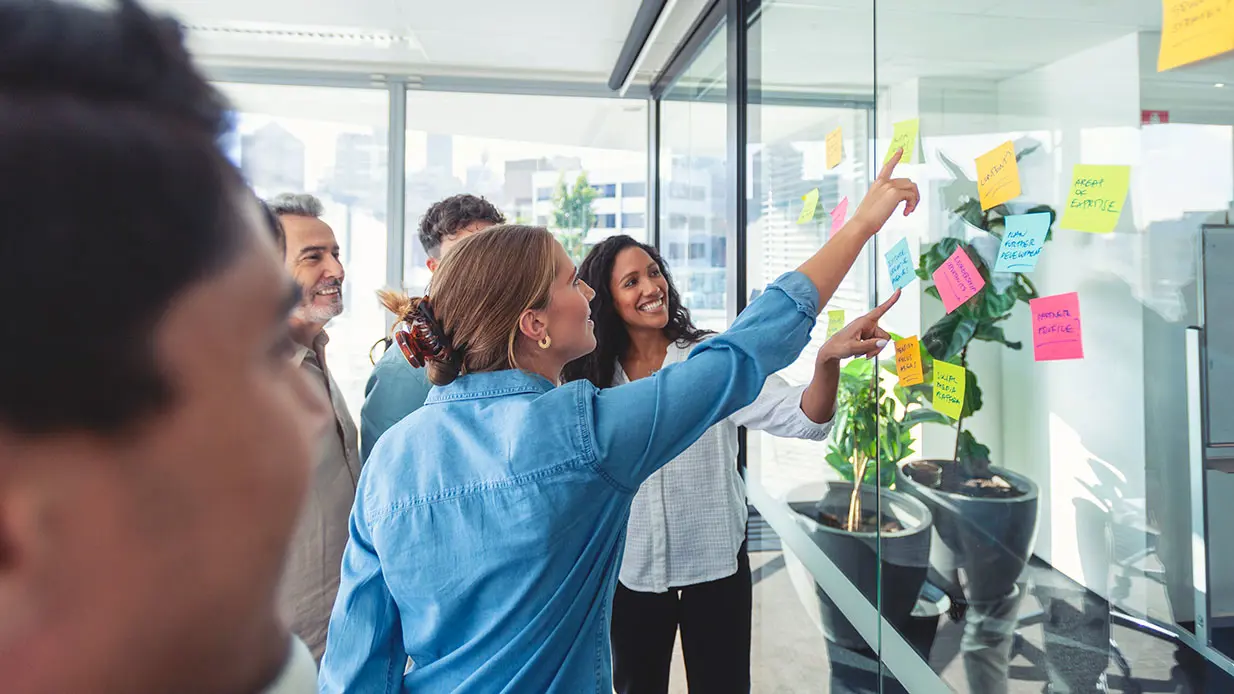 Group of people working with sticky notes on a glass wall for Safety Intervention Advanced training