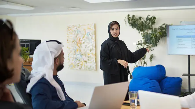A woman in a hijab giving a presentation.