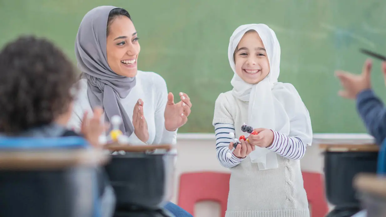 A happy teacher and student both smiling. 