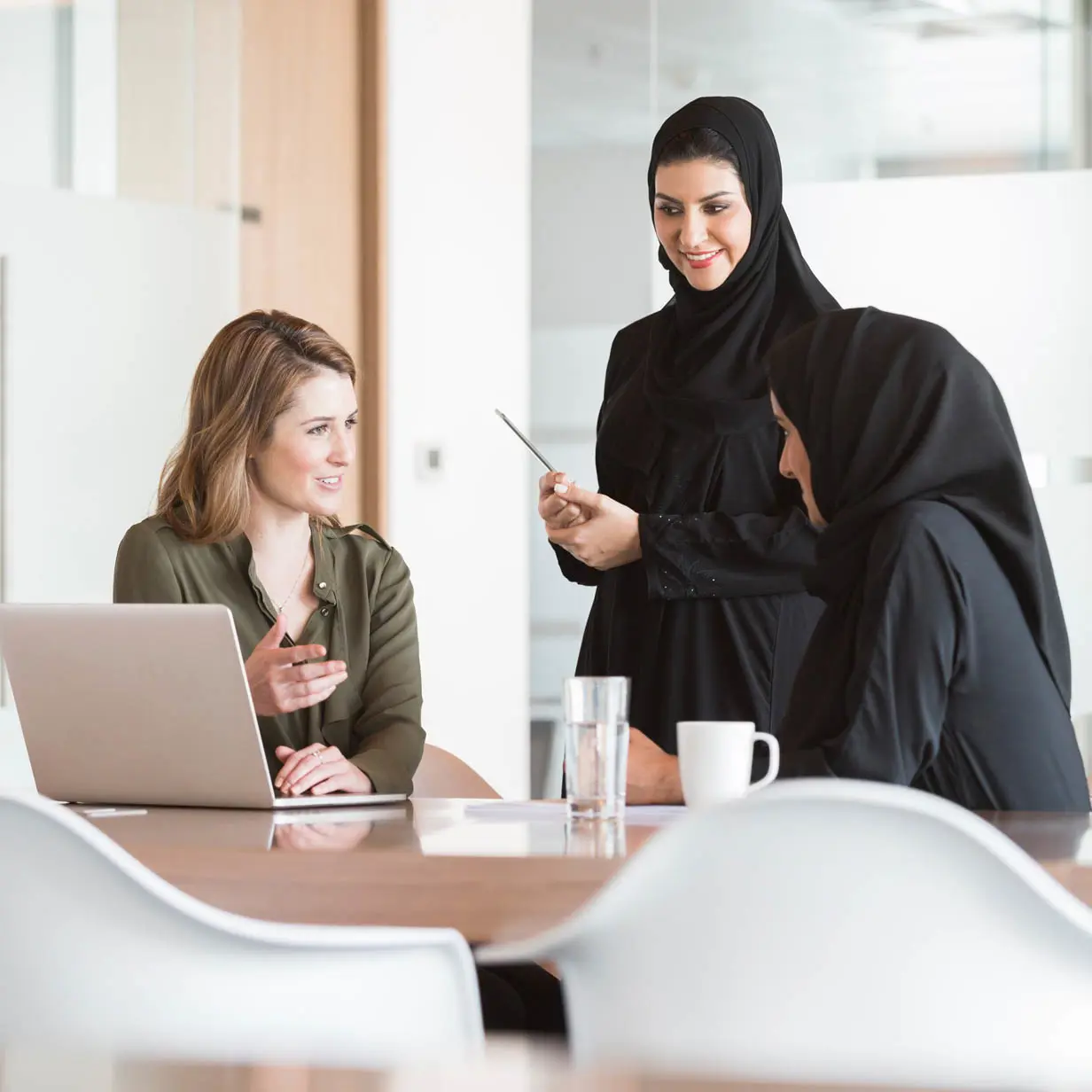 Three women having a conversation in the workplace. 