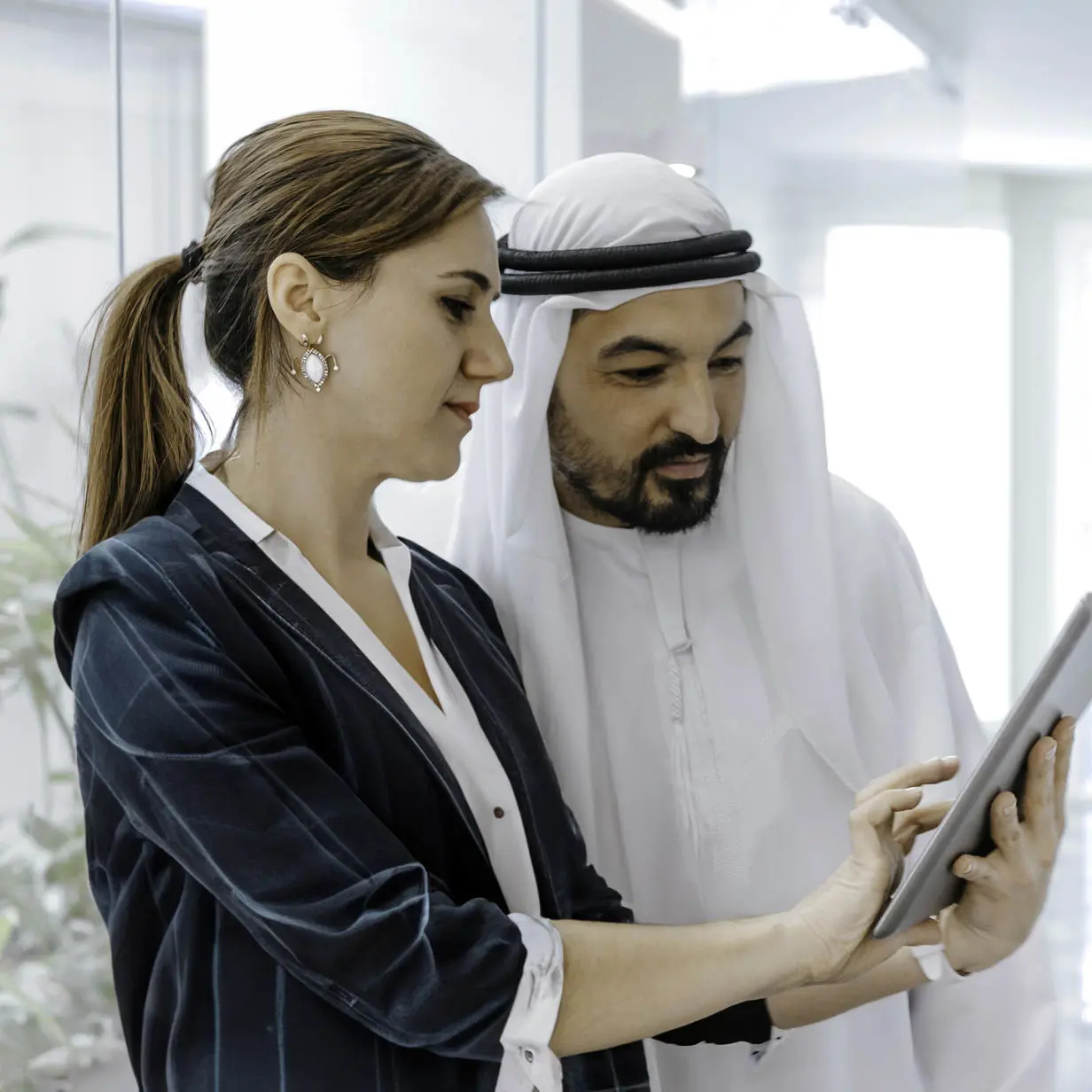 A man and woman talking together in a business setting and reviewing documents. 
