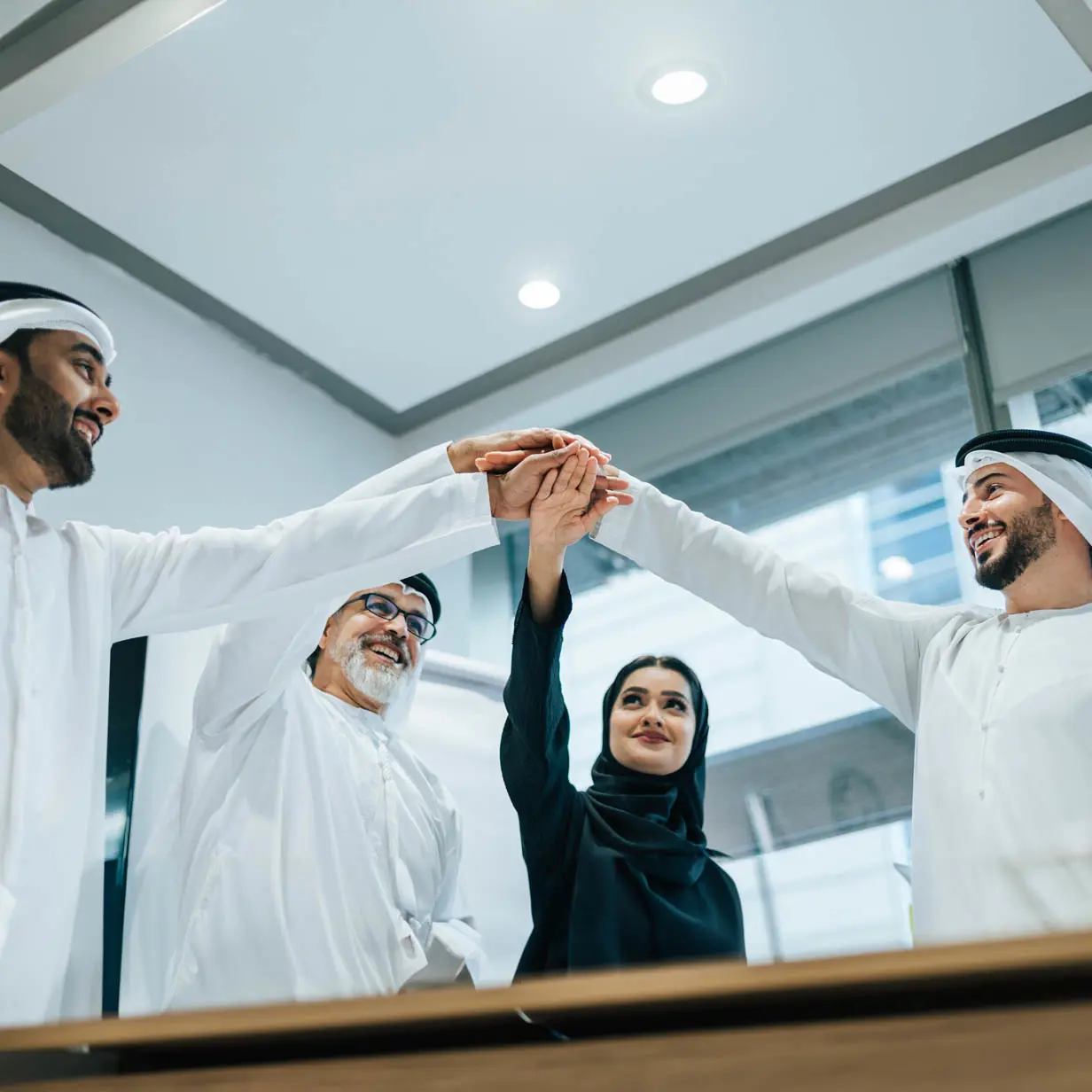 A team of employees putting their hands together after a meeting. 