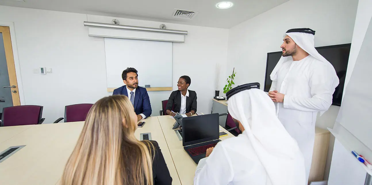 Two men in keffiyehs leading a meeting. 