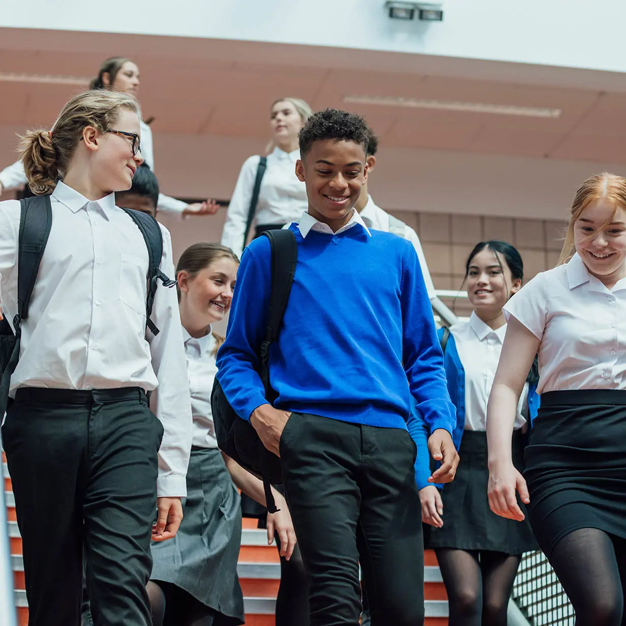 A group of smiling students leaving school. 