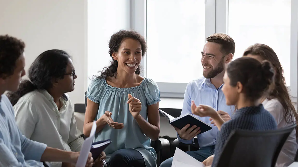 A group of smiling people sitting in a circle.