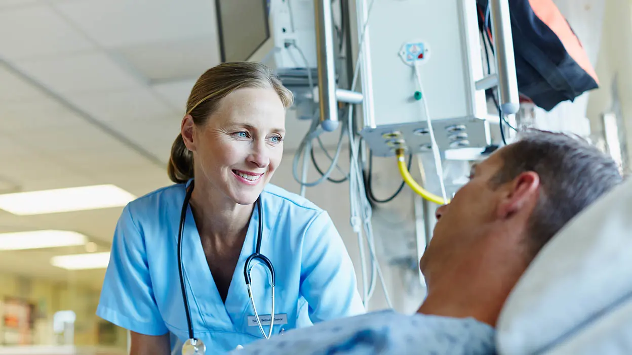 A medical professional at a patient's bedside.
