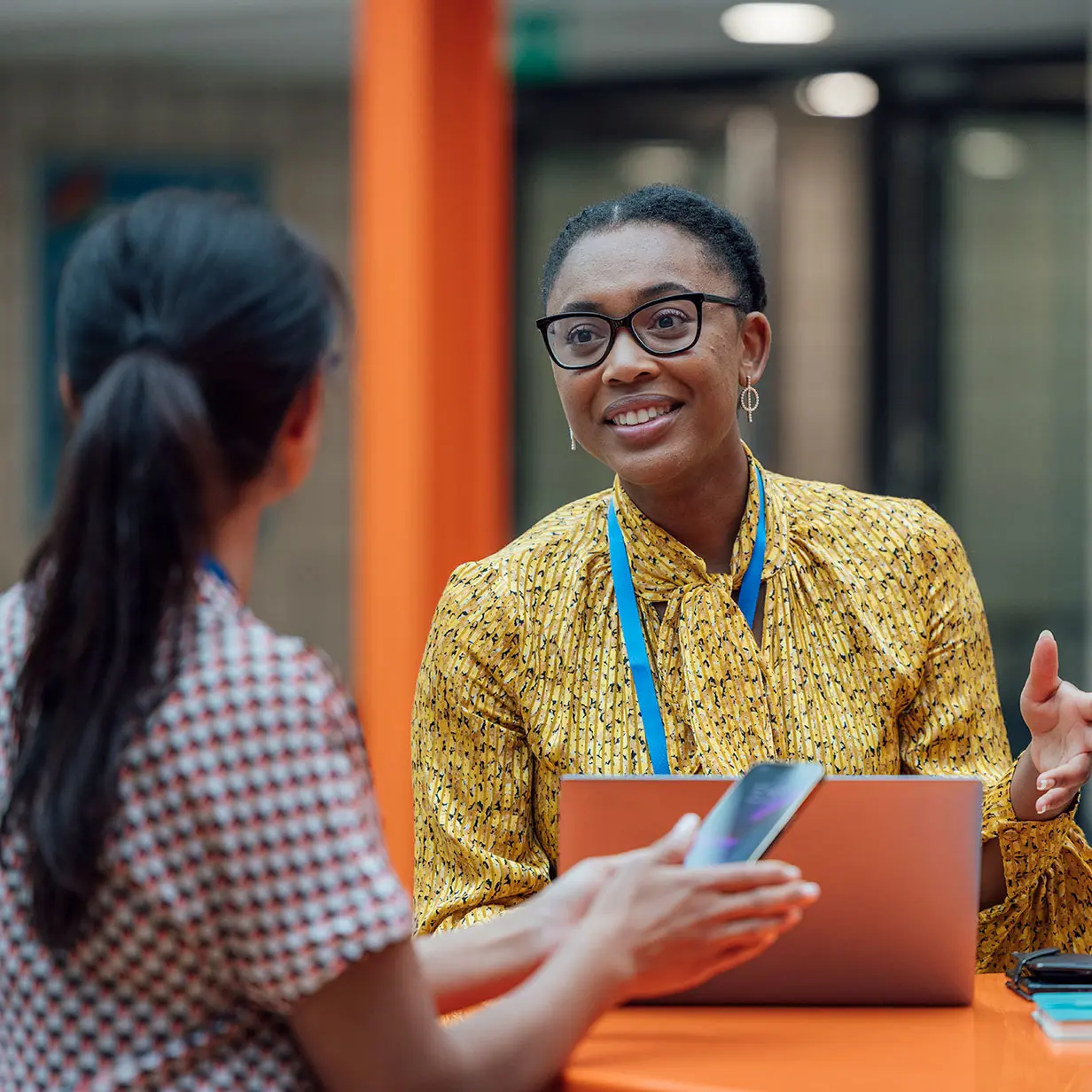 A woman with glasses in front of a laptop.