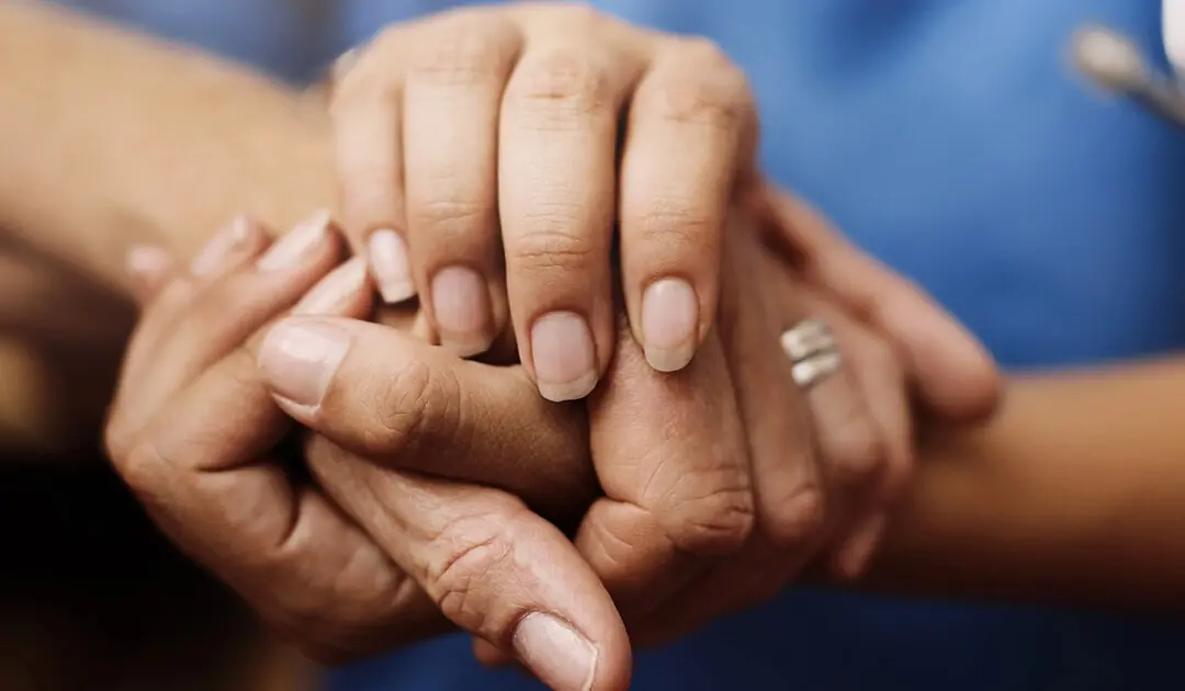 Two pairs of hands clasped together.