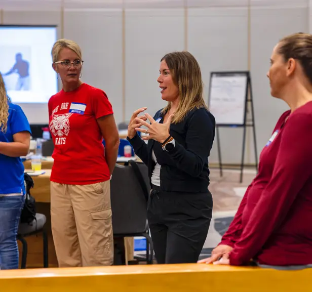 A woman standing in a group talking during CPI training.